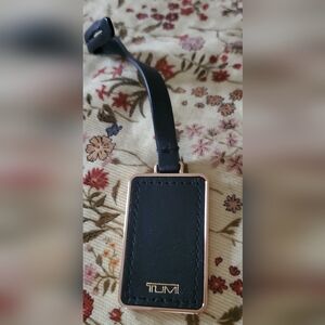 Tumi black and gold leather tag